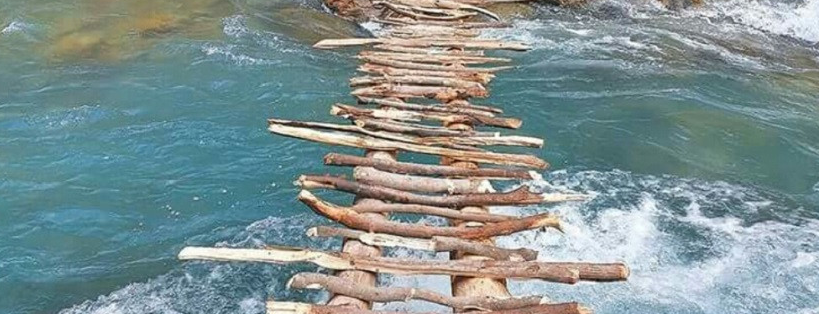 कालीकोटमा झोलुुङ्गे पुल बगाएपछि काठे पुल तर्न बाध्य